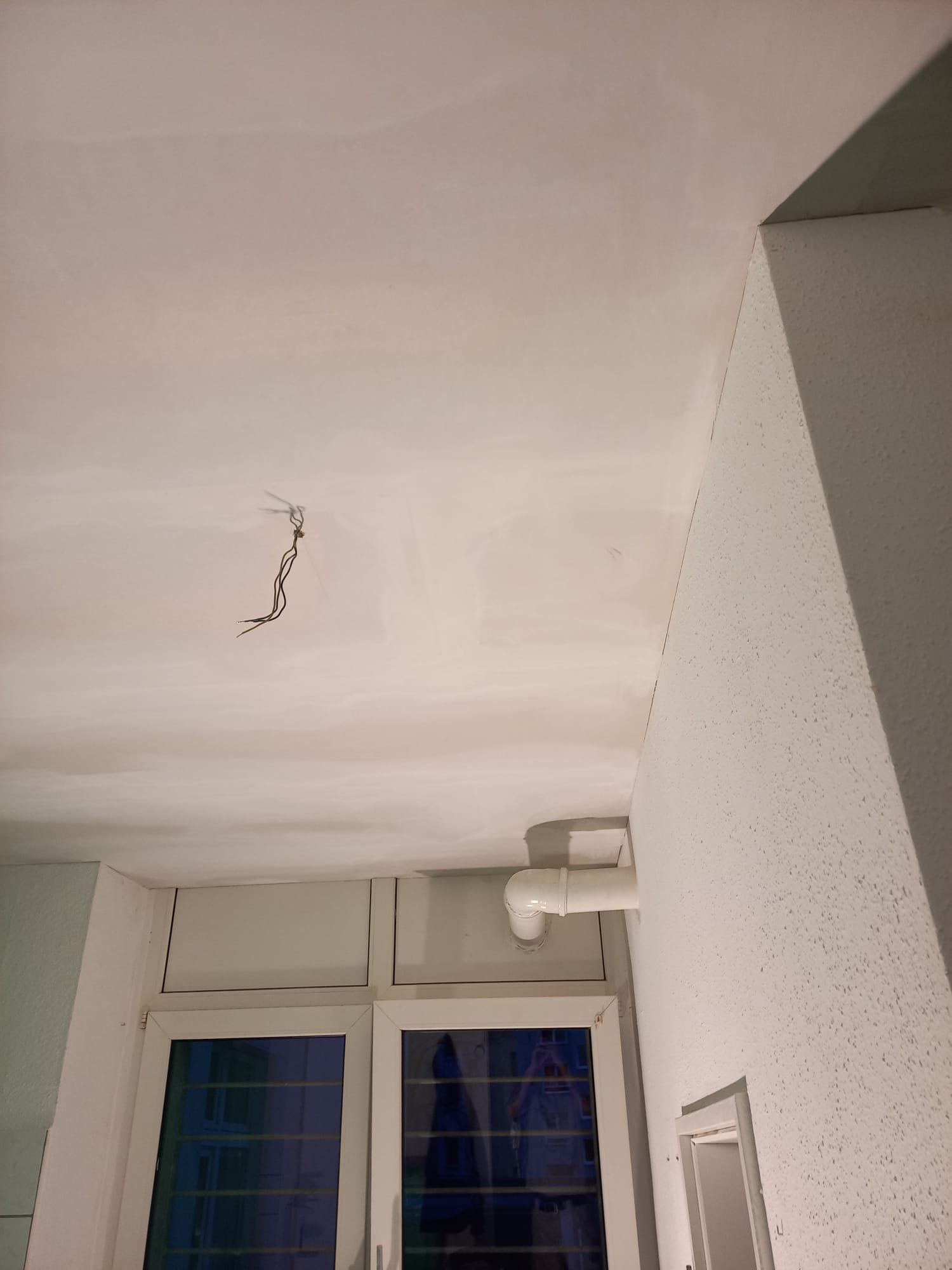Gespachtelte Deckenfläche mit vorbereiteter Wandfläche nach Wasserschaden